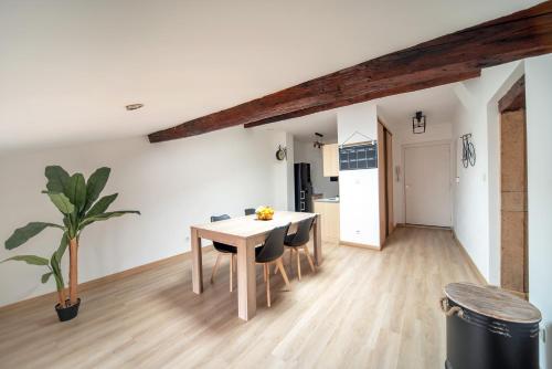 een keuken en eetkamer met een tafel en stoelen bij Appartement cosy et moderne en plein cœur du centre ville in Mâcon