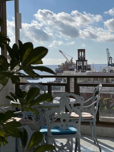 a table and chairs on a balcony with a clock tower at Hotel Atlántico Centro in Santa Cruz de Tenerife