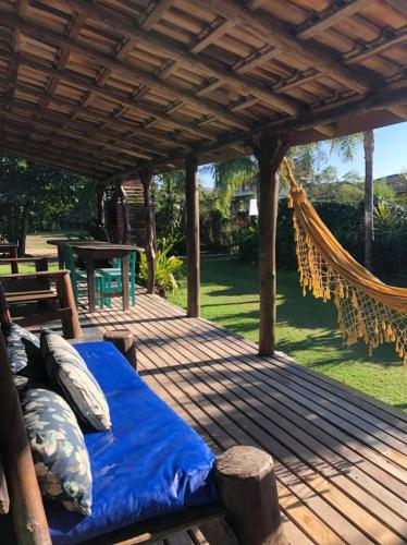 a bed on a wooden deck with a hammock at Morada Amazona in Praia do Rosa