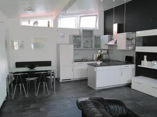 a kitchen with white cabinets and a table and chairs at Ferienwohnung an der Bergkirche in Bad Bergzabern