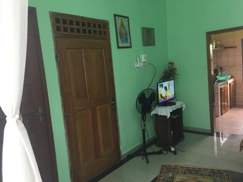 um quarto com uma porta de madeira e uma televisão em Vicky Appartements Palmengarten Douala Maképè Belavie em Douala