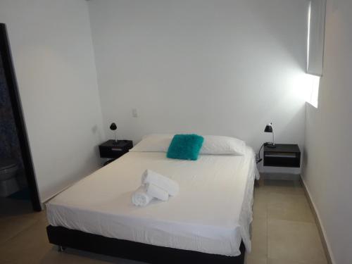 a bedroom with a white bed with towels on it at OUR Place 2 in San Andrés
