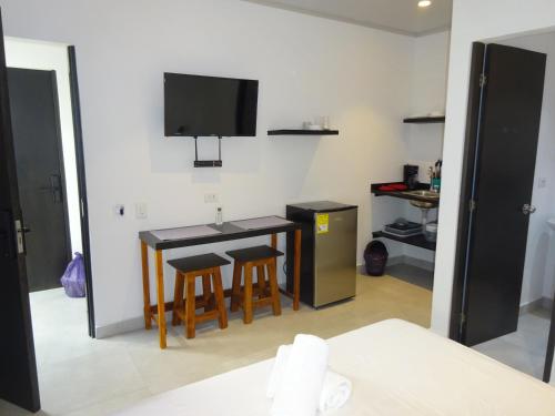 a room with a table and chairs and a tv at OUR Place 2 in San Andrés