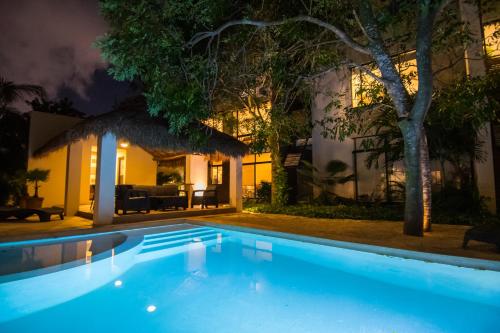 a swimming pool in front of a house at night at Tannah Luxury Rentals in Mérida