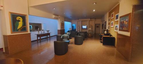 a living room with couches and a table and a living room with at Jandaia Hotel Campo Grande in Campo Grande