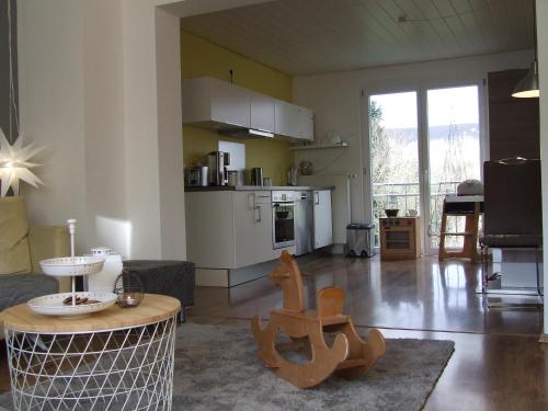 a living room with a table and a kitchen at Ferienwohnung Hochwald - im Herzen des Saarlandes in Quierschied