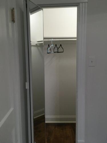 a glass door with two hangers in a closet at Logan Square Modern Apartment in Chicago