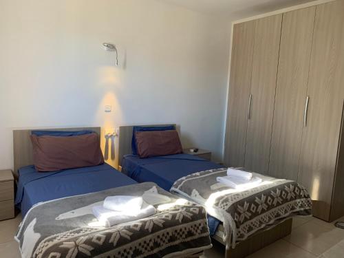 two beds in a room with blue sheets and towels at Mon-Chery in San Ġwann