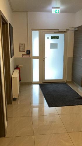 an empty room with a door with a sign on it at Hostel Ellwürder Hof in Nordenham
