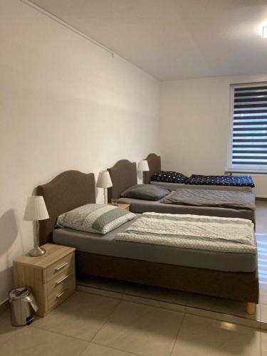 1 dormitorio con 2 camas, mesita de noche y ventana en Hostel Ellwürder Hof en Nordenham