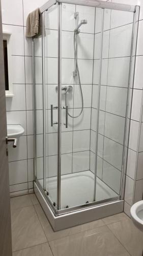 a shower with a glass door in a bathroom at Hostel Ellwürder Hof in Nordenham