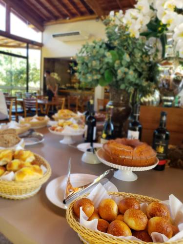 a table topped with baskets of bread and pastries at Hotel Chalés Capitanias in Águas de Lindóia