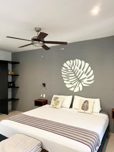 a bedroom with a large bed with a ceiling fan at Maya Eco Village in Akumal