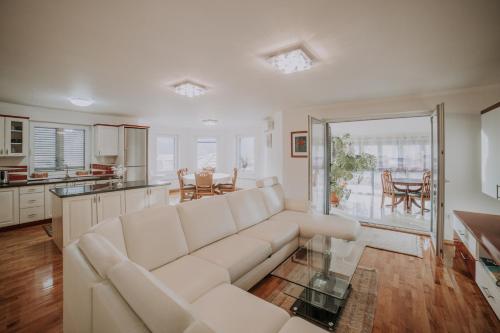 a living room with a white couch and a kitchen at Holiday Home Charlize in Sveti Martin na Muri