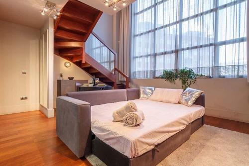 duże łóżko w pokoju ze schodami w obiekcie Apartamento DUPLEX ISOZAKI-GUGGENHEIM w mieście Bilbao