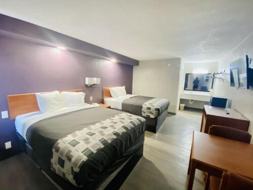 una camera d'albergo con 2 letti e una scrivania di Executive Inn a Kingsville