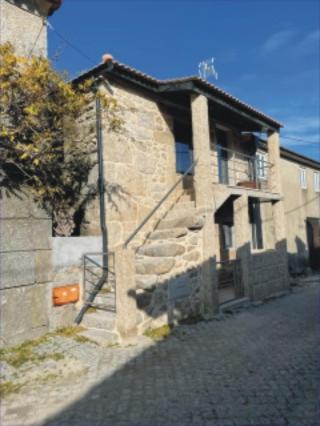un edificio in pietra con una scala sul lato di Casa Sofia a Vila Pouca de Aguiar