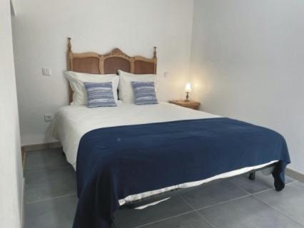 a bedroom with a large bed with a blue blanket at Casa Sofia in Vila Pouca de Aguiar