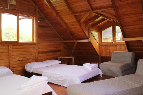 a room with two beds and a chair and windows at Finca Chalet La Tawa in Sevilla