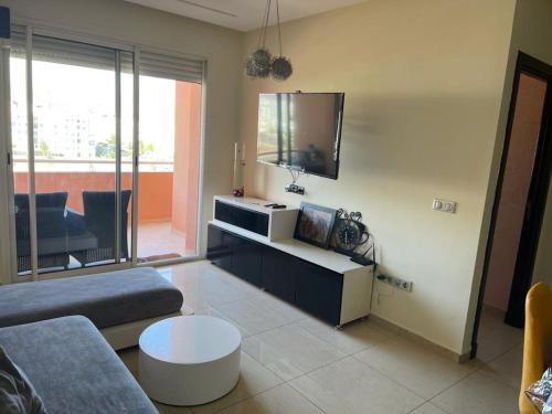 een woonkamer met een bank en een tv bij appt islane gh25 in Agadir
