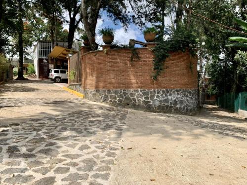 a brick wall with potted plants on top of it at Quinta Maria Bonita Hotel Boutique in Xalapa