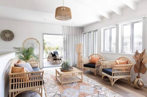 a living room with chairs and couches at Currumbin Sanctuary Beach Abode in Gold Coast