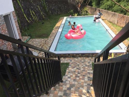 a group of people in a swimming pool with an inflatable at Villa Kay Mountain in Bogor