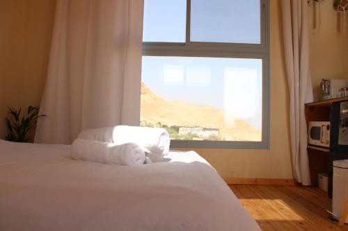 a bedroom with a bed with towels on it at Dead Sea Rooftop - גג ים המלח in Ovnat