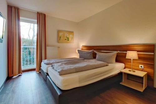 Un dormitorio con una cama grande y una ventana en Strandnahe-Ferienwohnung-201-Residenz-Hohe-Lith-Duhnen-mit-Sky-TV, en Cuxhaven
