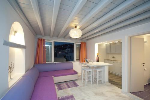 a living room with a purple couch and a kitchen at Mykonos Marina in Mikonos