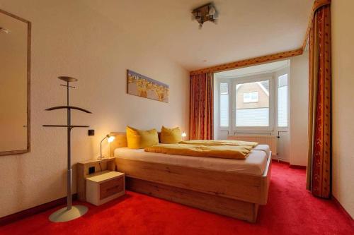 een slaapkamer met een bed met een rode vloer en een raam bij Ferienwohnung-48-mit-Meerblick-Residenz-Meeresbrandung-Duhnen in Cuxhaven