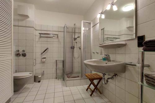 een badkamer met een wastafel, een douche en een toilet bij Ferienwohnung-48-mit-Meerblick-Residenz-Meeresbrandung-Duhnen in Cuxhaven