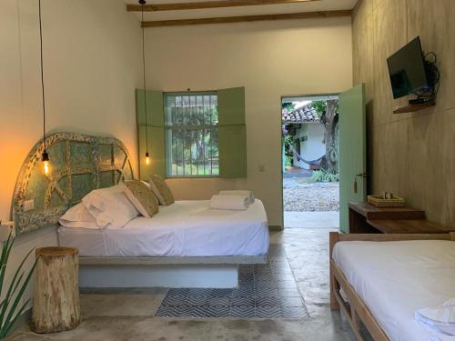 a bedroom with two beds and a door to a yard at Waka Hotel Rural in Honda