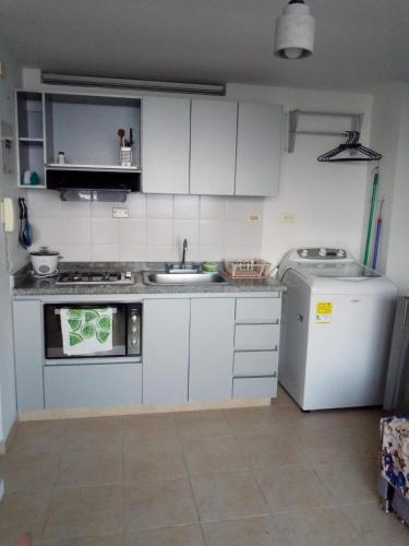 a small kitchen with a sink and a refrigerator at Aparta- Estudio Amoblado in Ibagué