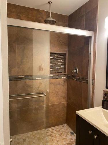 a shower with a glass door in a bathroom at The Brick House in McAllen