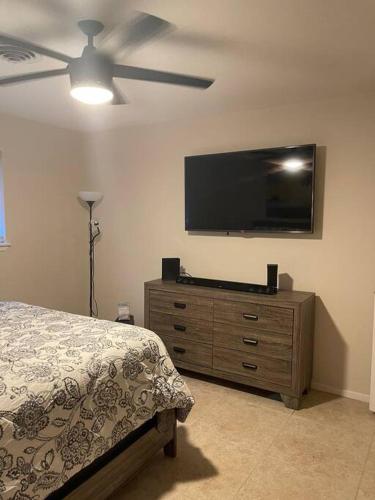 a bedroom with a bed and a flat screen tv at The Brick House in McAllen