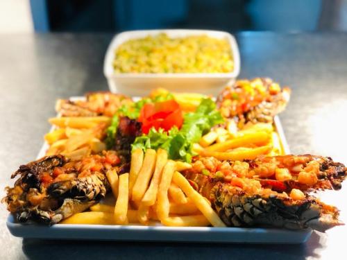 a plate of food with meat and french fries at Gran Lençóis Flat Apartamento in Barreirinhas