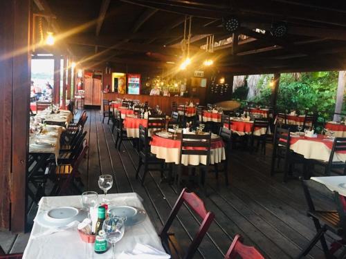 a dining room with tables and chairs in a restaurant at Gran Lençóis Flat Apartamento in Barreirinhas
