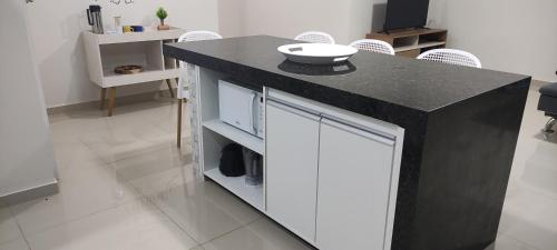 a kitchen with a black counter and white cabinets at Condomínio Vila da Praia em São José - Maragogi in São José da Coroa Grande