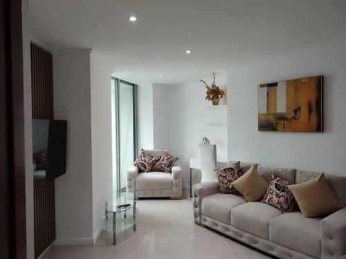 Suite exclusiva con balcón y maravillosa vista في غواياكيل: غرفة معيشة بها كنبتين وطاولة زجاجية
