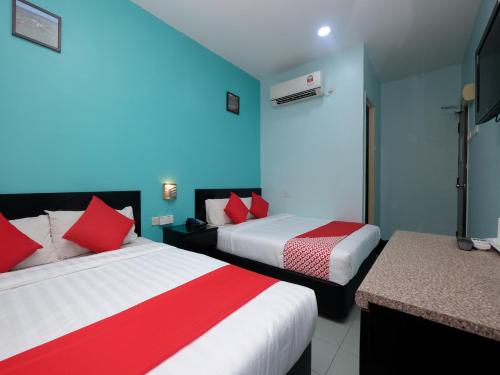 a hotel room with two beds with red and white pillows at Marjan Hotel Sdn Bhd in Cukai