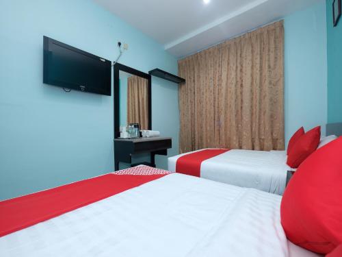 a hotel room with two beds and a flat screen tv at Marjan Hotel Sdn Bhd in Cukai