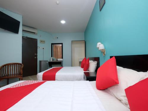 a hotel room with two beds with red pillows at Marjan Hotel Sdn Bhd in Cukai