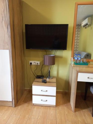 una TV a schermo piatto su una parete con una cassettiera e una scrivania di Bangi Gateway Suite a Kampong Sungai Merab