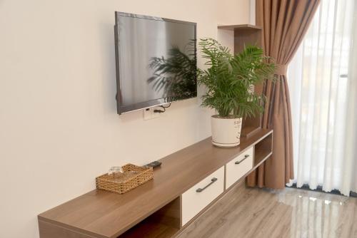 Phương Linh Hotel في دالات: غرفة معيشة مع طاولة مع تلفزيون والنباتات