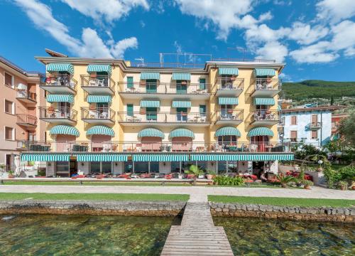 a hotel with a river in front of it at Hotel Nettuno in Brenzone sul Garda