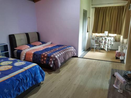 Un dormitorio con 2 camas y una mesa en una habitación en Cassava Homestay - Rumah Santai, en Kampong Lamanak