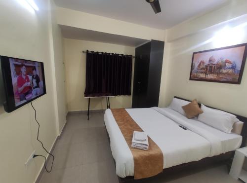 a bedroom with a large bed and a flat screen tv at StayVilla Royal in Rānchī