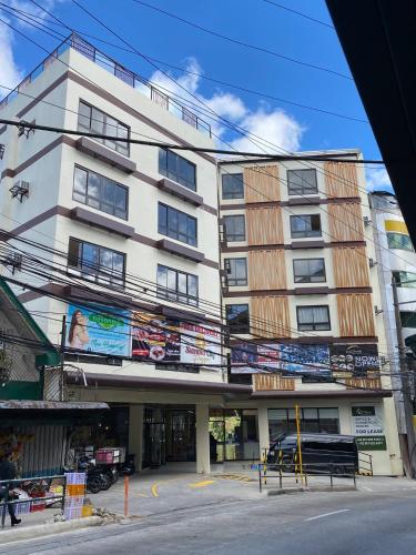 um edifício branco alto com muitos sinais nele em Olive Town Center and Hotel em Baguio