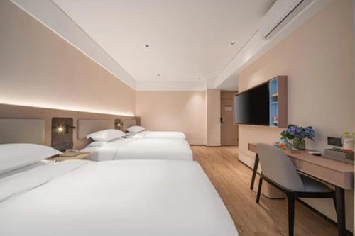 Cette chambre comprend 3 lits et une télévision. dans l'établissement 银座佳驿酒店（郓城汽车站店）, à Yuncheng